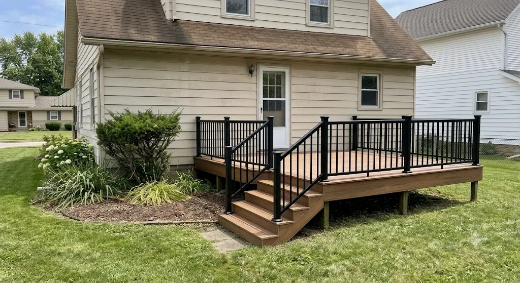 New composite deck with black aluminum railing and matching stairs on the same home after rebuild